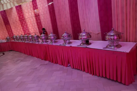 Covered serving dishes on a draped buffet counter