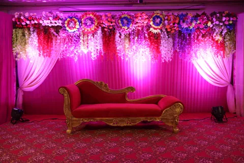 Hanging flowers and drapes behind stage seating